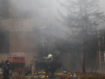 Emergency personnel work at the site of a helicopter crash, amid Russia's attack on Ukraine, in the town of Brovary, outside Kyiv.