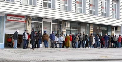 Spaniards wait in line outside a job center.