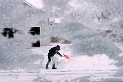 A local resident shovels snow off the end of a driveway in Urbandale, Iowa.