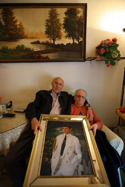 Manuel Espí and María Martínez in their home with a photograph of Lucas at his first communion.