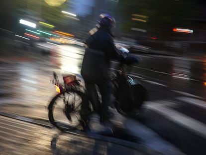 A food delivery worker rides in the night along Brooklyn's Bedford Avenue, Friday, April 28, 2023, in New York.