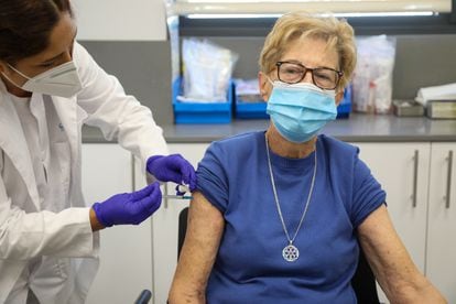 A senior in Madrid receives a Covid-19 booster shot and flu vaccine, in a file photo from October 2021.