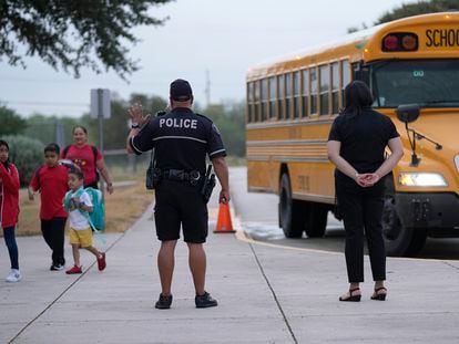 Southside Independent School District police officer Ruben Cardenas, center, keeps watch as students arrive at Freedom Elementary School, Wednesday, Aug. 23, 2023, in San Antonio.