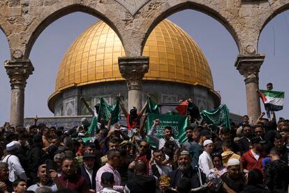 Palestinians hold the Palestinian national flag and the flag of the Hamas militant group during a protest by the Dome of Rock at the Al-Aqsa Mosque.