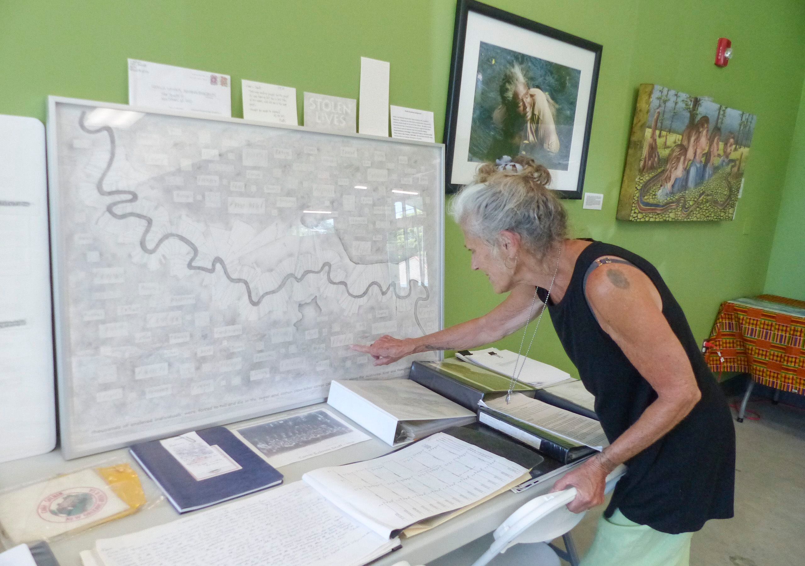 Phyllis Goodnow points out her illustration of plantations on the banks of the Mississippi River at the Katrina National Memorial Foundation Museum in New Orleans.