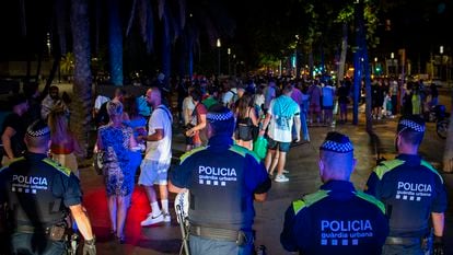 Police break up an outdoor drinking session in Barcelona being held in violation of the curfew last summer.