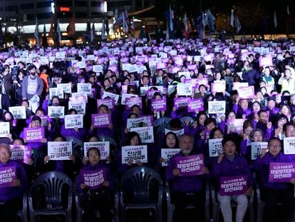 People hold the signs during a rally marking the first anniversary of the harrowing crowd surge that killed about 160 people in a Seoul alleyway, at the Seoul Plaza in Seoul, South Korea, Sunday, Oct. 29, 2023. The signs read "Find out the truth."