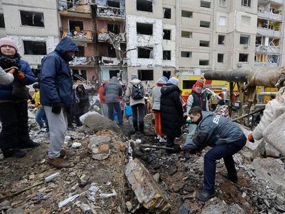 Ukrainian volunteers remove debris from a building hit in Kyiv by missiles launched by Russia last Tuesday.