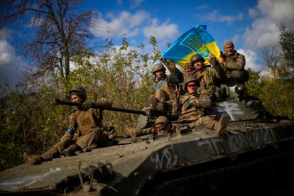 Ukrainian soldiers sit on an armoured vehicle on a road between Izium and Lyman, recently retaken areas in Ukraine, on Oct. 4, 2022. 
