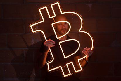Podcaster Pau Ninja poses with a neon Bitcoin symbol.