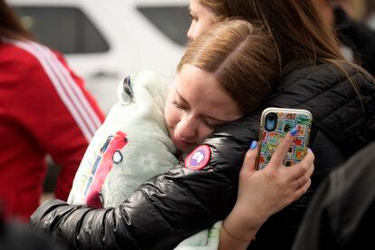 Two women hug when reunited following a shooting at East High School, on March 22, 2023, in Denver.