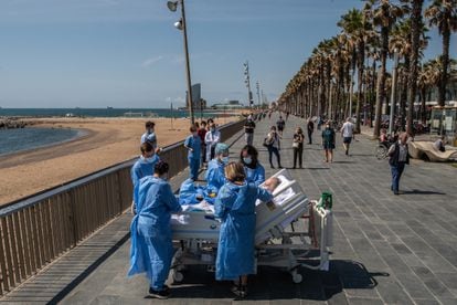 Staff at the Mar de Barcelona hospital take a Covid-19 patient to the seaside as part of a program to humanize intensive care treatment.