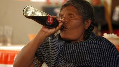 A Mazahua woman drinking Coca-Cola.
