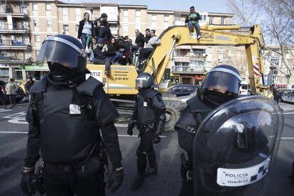 Madrid municipal police officers stand in front of protestors who climbed on to a digger to try to prevent the eviction of number 29, Ofelia Nieto street. The property, on the border between the capital’s Moncloa and Tetuán districts, was the last to be evicted as part of a local development plan.