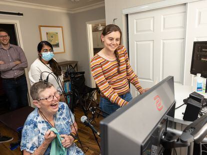 Pat Bennet, one of the patients, stands with Stanford researchers during a test session of the technology that restored her speech.