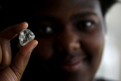 A visitor holds a diamond during a visit to the De Beers Global Sightholder Sales (GSS) inGaborone, Botswana November 24, 2015