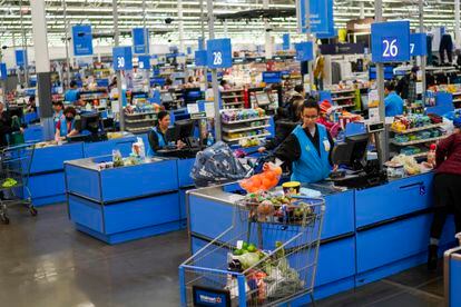 Cashiers process purchases at a Walmart Supercenter in North Bergen, N.J., on Thursday, Feb. 9, 2023.