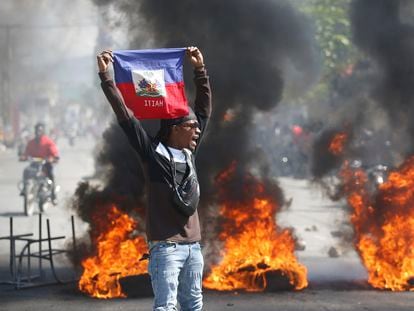 A demonstrator holds a Haitian flag during a protest in Port-au-Prince, on March 1, 2024.