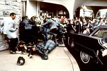 This photo taken by presidential photographer Michael Evans on March 30, 1981, shows police and Secret Service agents reacting during the assassination attempt on Ronald Reagan.