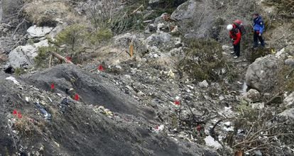 Members of the recovery team walk among debris from the Germanwings plane at the crash site.