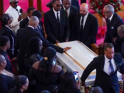 Andre Zachery, father of Jordan Neely places his hand on Neely's casket, after a funeral service at Harlem's Mount Neboh Baptist Church, Friday May 19, 2023, in New York.