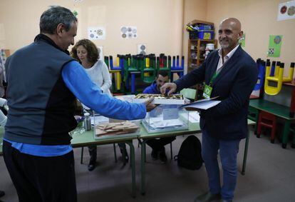 A worker at a polling station in Galapagar hands out chocolates. 
