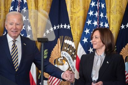 US President Joe Biden (L) holds US Vice President Kamala Harris' (R) hand