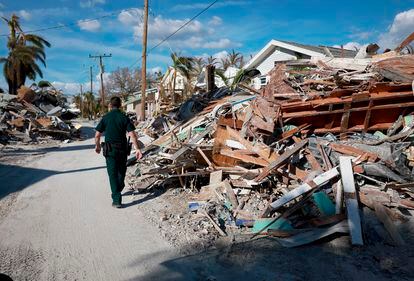 A Lee County Sheriff in Florida surveys the debris left behind by Hurricane Ian.
