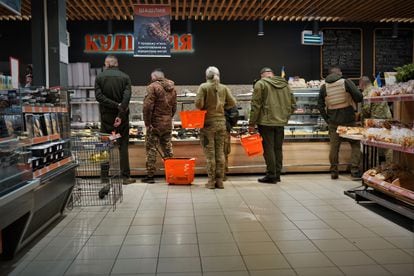 Ukrainian soldiers do their shopping at a grocery store in Kramatorsk, in the Donetsk region, on May 10, 2023.