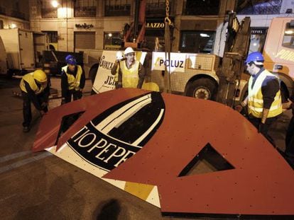 Workers prepare a section of the Tío Pepe sign before it is lifted into place.