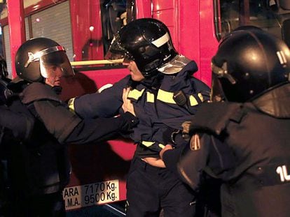 Police arrest a firefighter during the protest (Spanish narration).