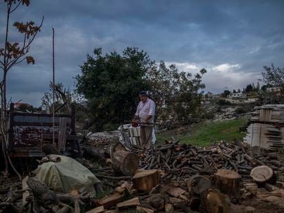 Sayed Sanki, 54, chops wood to heat his home in Mayfouk, northern Lebanon, last November.