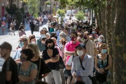 Dozens of citizens wait in line in Barcelona on Tuesday to swap their pesetas for euros at the Bank of Spain.