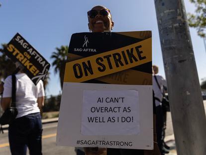 A protestor holds a poster reading 'AI Can't Overact as Well as I Do' as SAG-AFTRA members demonstrate in front of Netflix headquarters in Los Angeles, California, Nov. 8, 2023.