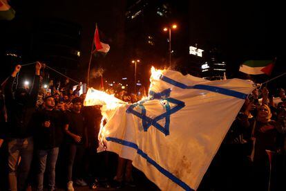 Protesters burn an Israeli flag in front of the Israeli consulate in Istanbul on Tuesday night.