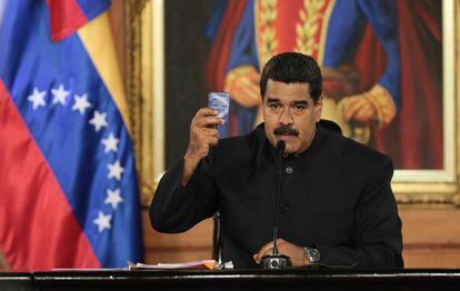 Maduro holds a copy of the Venezuelan Constitution during a speech.