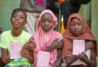 Three girls show their HPV vaccination cards in Nigeria on October 26, the first day of the immunization campaign to protect 7.7 million girls aged 9-14 years.