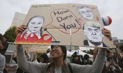 A protestor holds a handmade sign with an image of Greta Thunberg and her famous phrase, “How dare you?” directed at American President Donald Trump and South Korean President Moon Jae-in, in Seoul, South Korea.