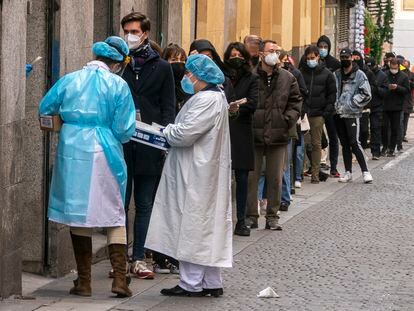 People wait in line to get a PCR test outside a primary healthcare center in Madrid.