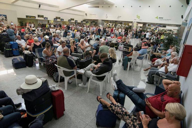 Tourists await their flights in Menorca airport.