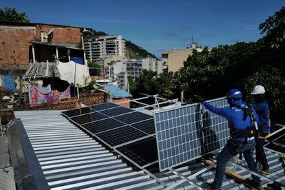 Workers from the non-profit organization Revolusolar install solar panels in a favela in Rio de Janeiro, Brazil, on March 1.
