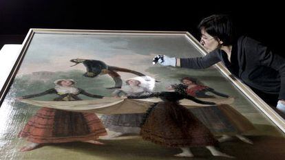 A conservationist inspects the Goya painting El Pelele before it was hung for the CaixaForum exhibition in Barcelona. 