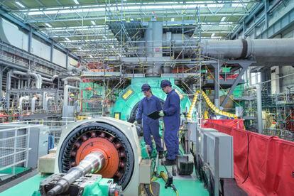 Two engineers inspect generator machinery at a nuclear power plant