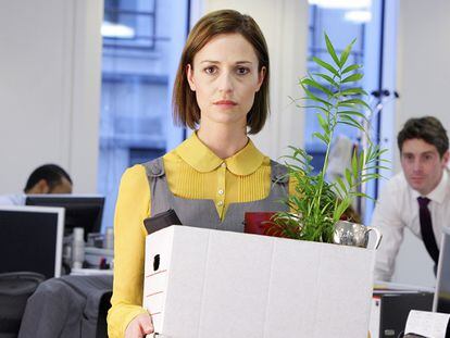 A woman leaving the office with her belongings.